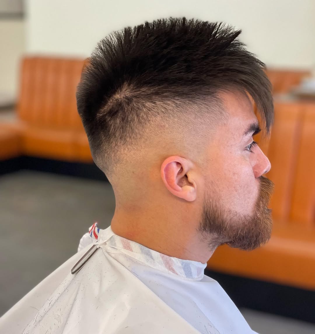 spiky hair and long side swept bangs featuring a high skin fade
