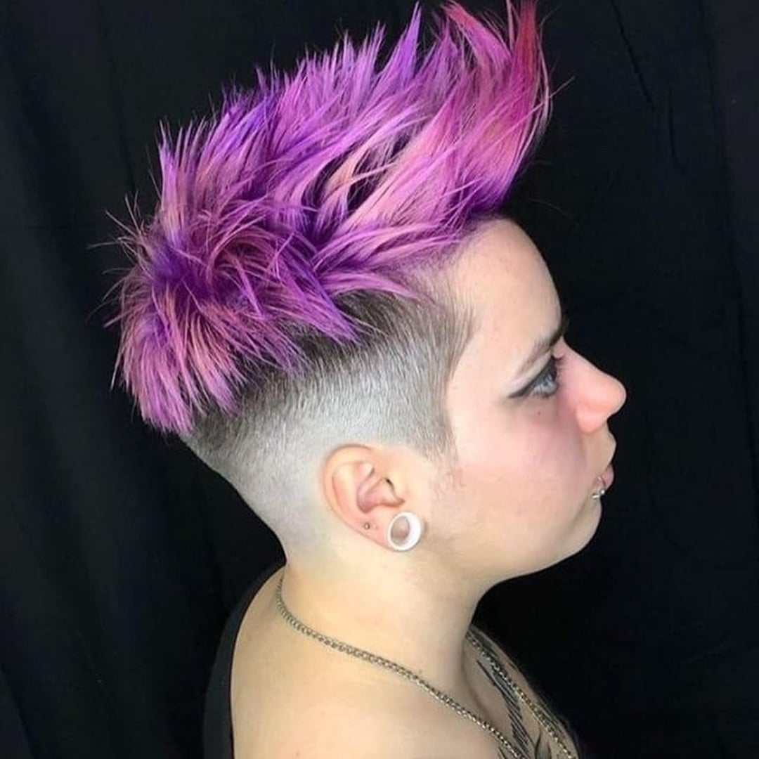 woman with a spiky purple mohawk pixie cut featuring shaved side