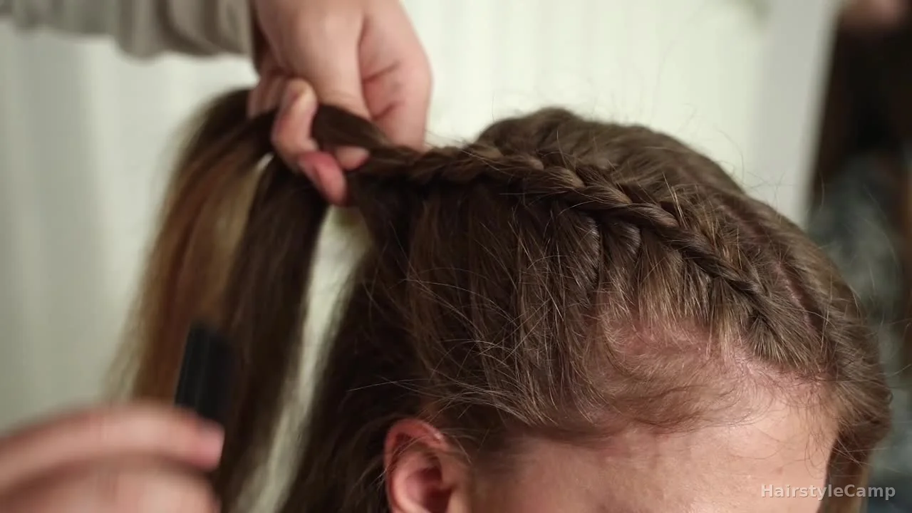 Braid moving past the temple while staying close to the side of the head above the ear.