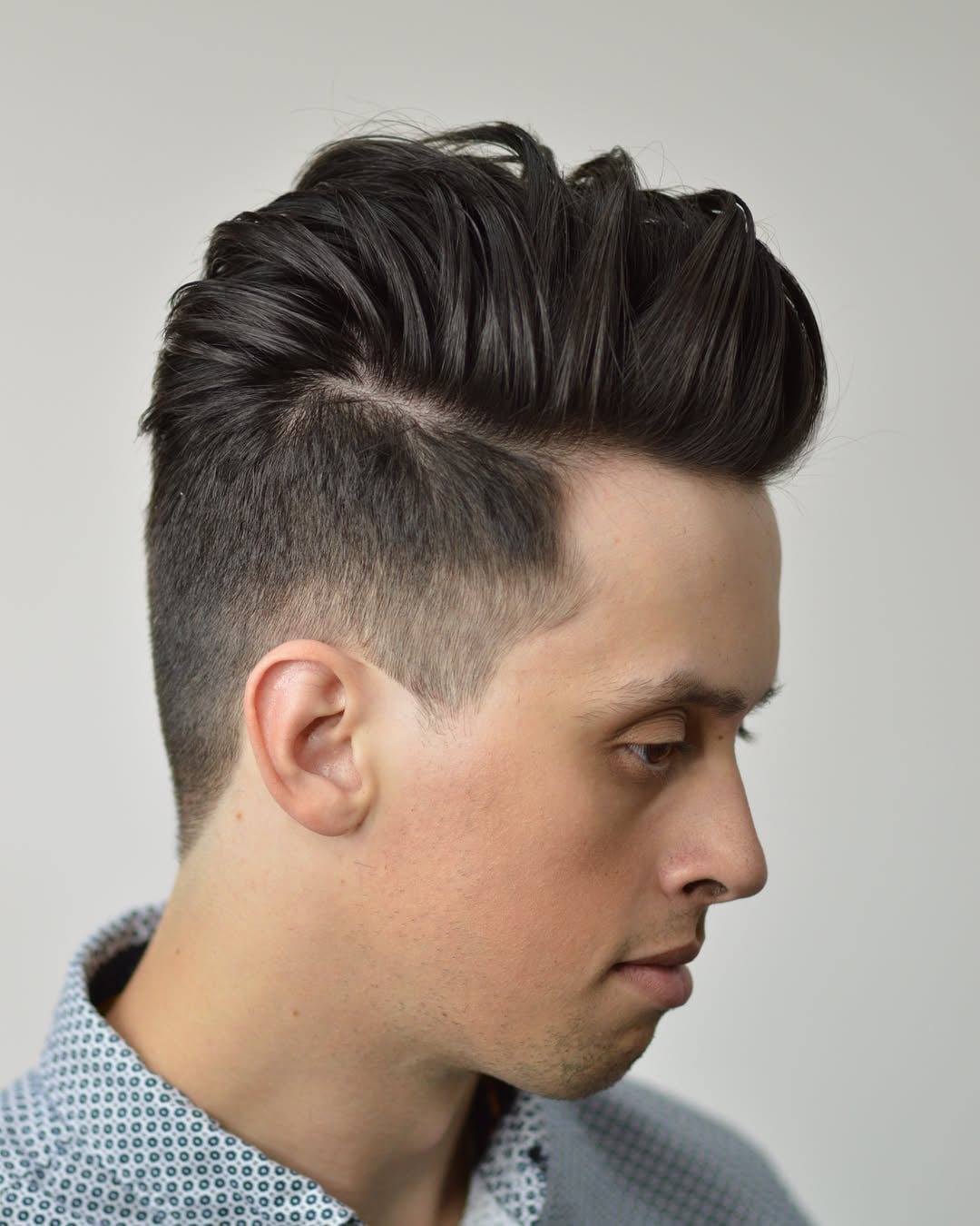 voluminous straight blowout hair for men featuring textured top volume, a hard side part