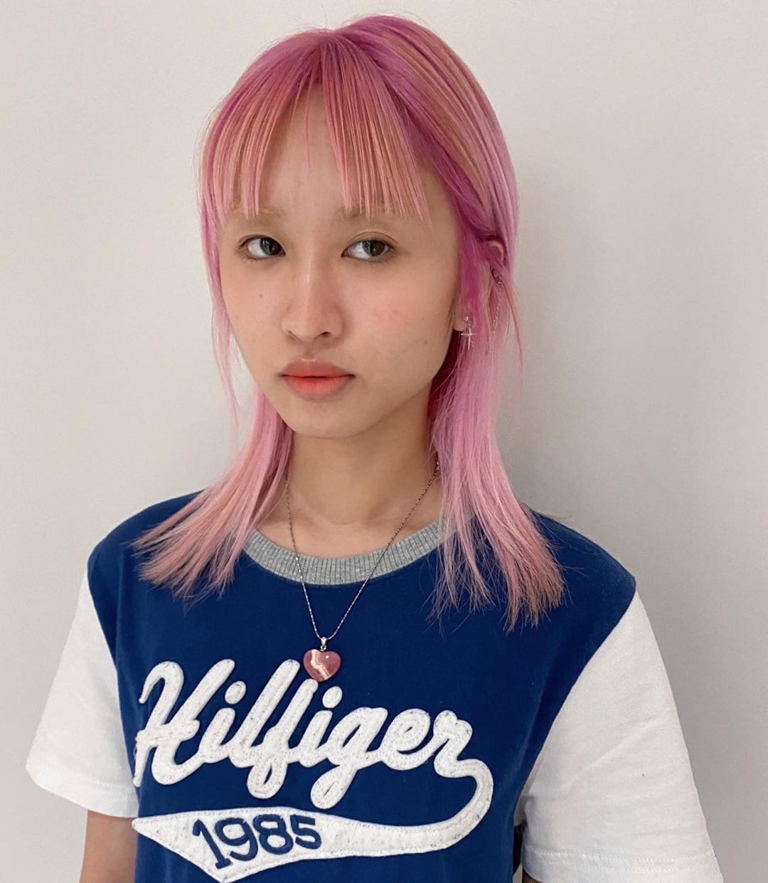 Mid-length straight pastel pink hair featuring thin see-through bangs