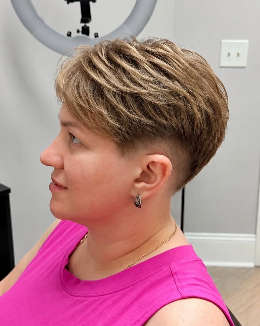 Tapered pixie with blonde highlights, tousled top layers, and short sides and nape
