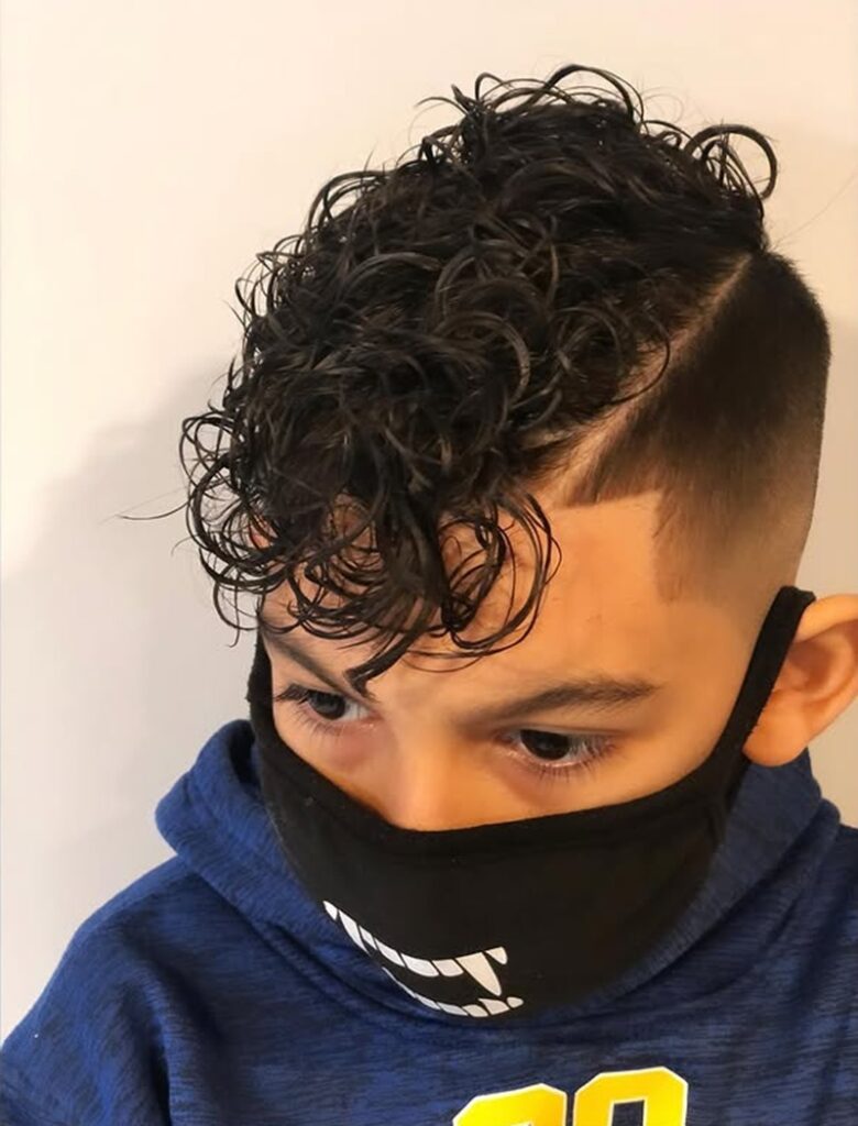 young boy with voluminous curly comb over undercut