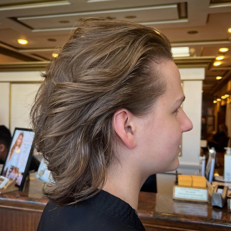 teen boy with voluminous, swept-back layered brown hair