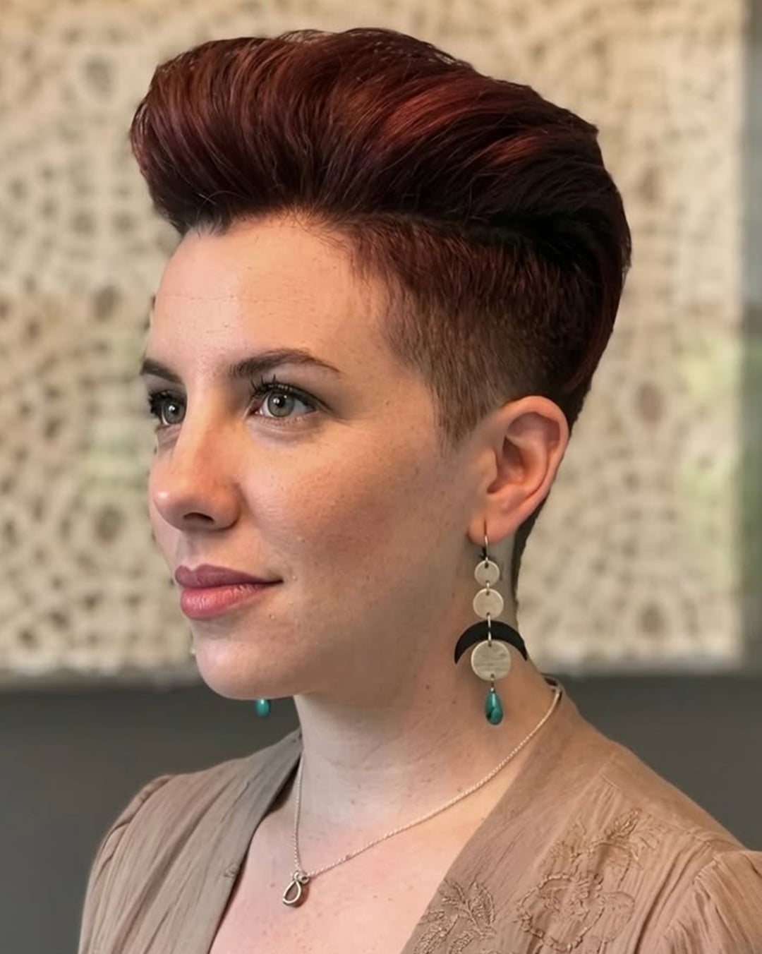 Woman with a voluminous mahogany red pompadour pixie cut for thick hair