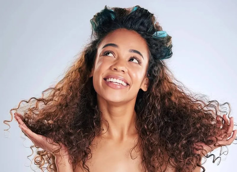 voluminous multi-textured curls being styled with rollers