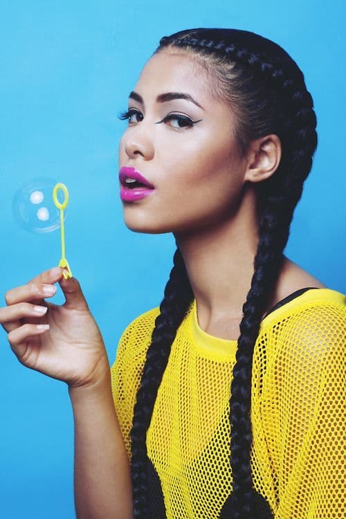 Woman wearing two long big braids with weave s