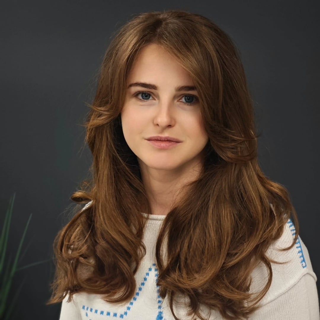voluminous long layered haircut with loose curls and face-framing bangs