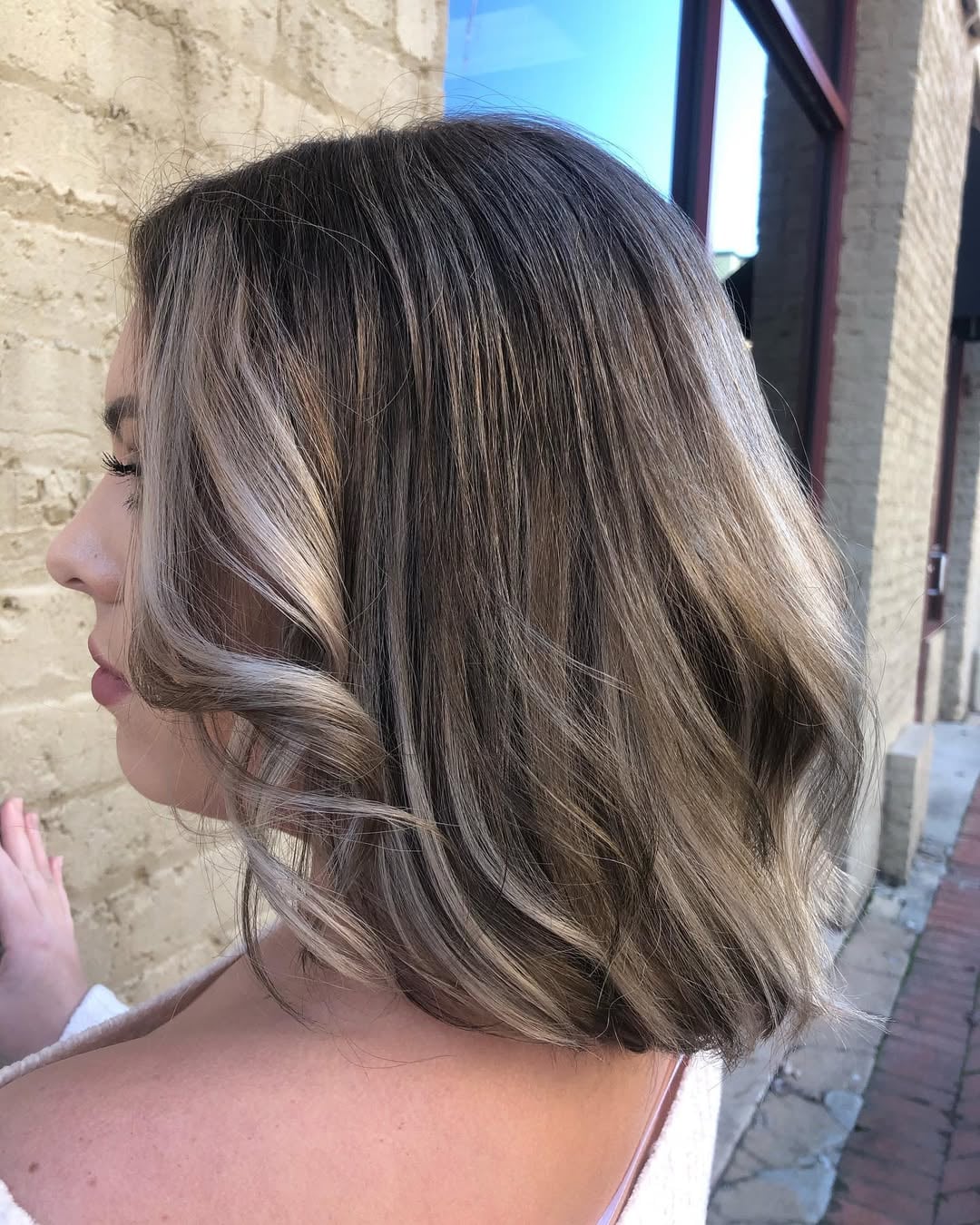 Wavy lob haircut and cool face-framing mousy brown hair highlights