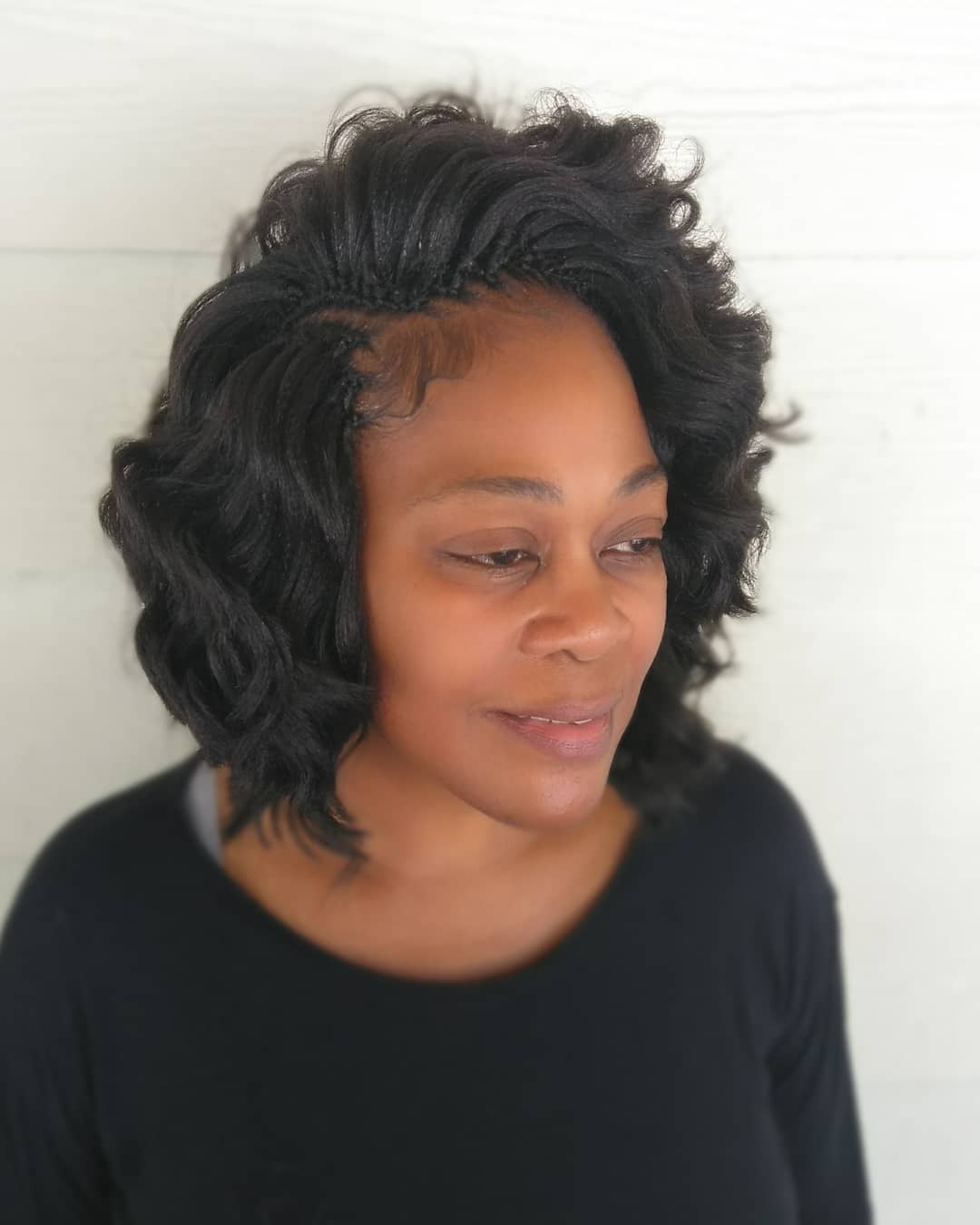 Short wavy black bob crochet braids with a deep side part and smooth laid edges