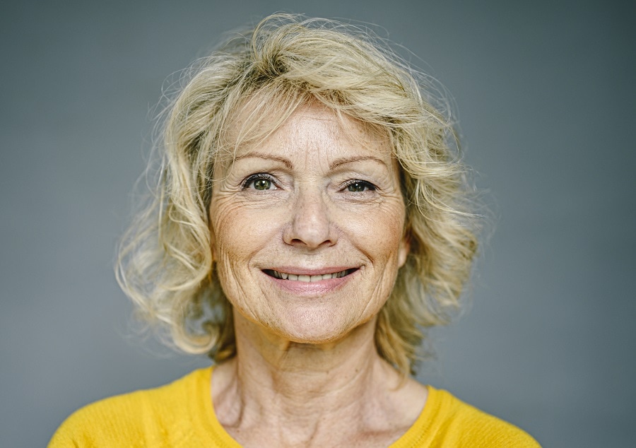 woman over 60 with medium permed hairstyle