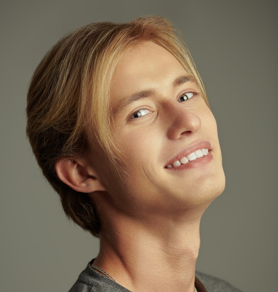 A young man with blond hair in the middle part
